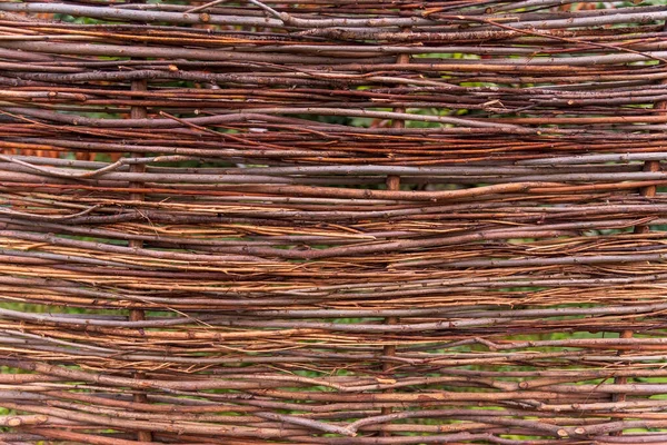 Ein Zaun aus geflochtenen Ästen, um eine ökologisch nachhaltige Mauer im Hinterhofgarten zu schaffen. Hintergrund, Textur, Dekorelement — Stockfoto