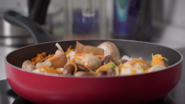Kızartma tavasında sebze pişirmek, mantar, bezelye, soğan, havuç. Seçici odak — Stok video