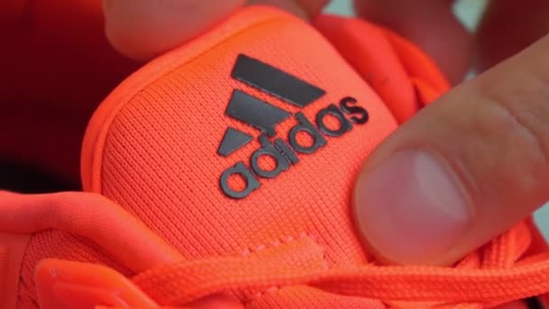 Tyumen, Oroszország-november 13, 2021: Adidas logó narancssárga futócipőn közelkép. Szelektív fókusz — Stock videók