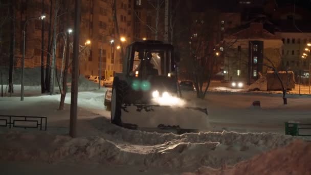 Snow plow on road at night, cleaning city street from snowdrift after heavy snowfall. Selective focus — Stock Video