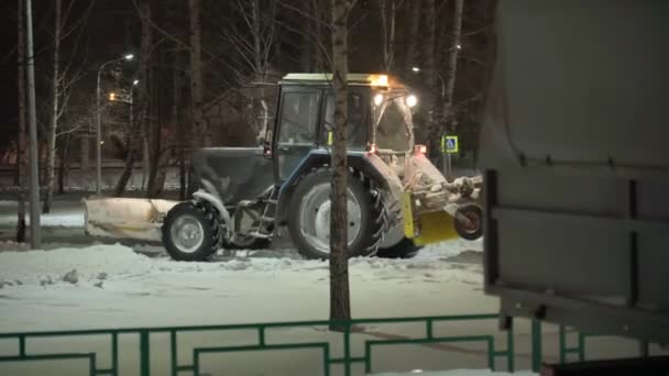 Tyumen, Rusko-prosinec 24, 2021: Snow removal equipment working. Sněhová bouře nebo sněhová bouře ochromily město. Koncept zimní sezóny. — Stock video