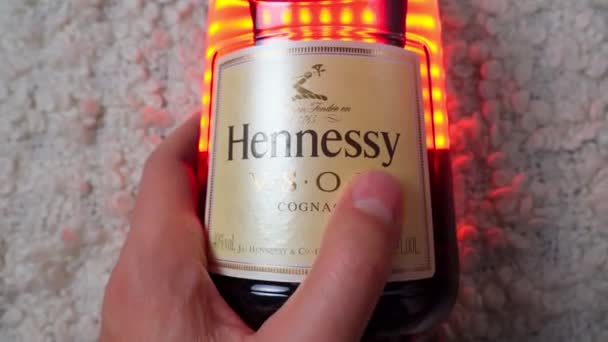 Tyumen, Russia-November 27, 2021: Hennessy vsop logo in hand, the brand of the famous cognac from France. Enfoque selectivo — Vídeo de stock