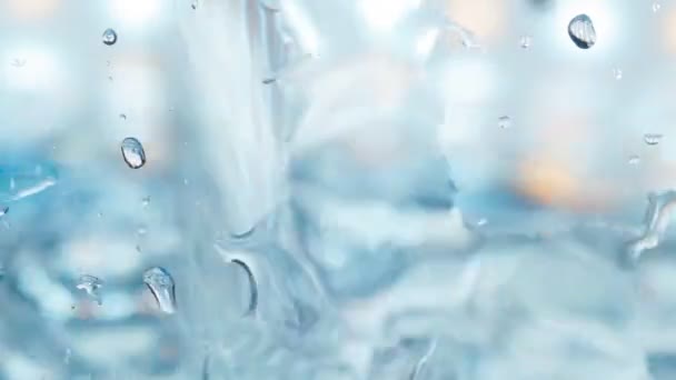 Vizet öntenek egy üvegtartályba közelkép, szelektív fókusz, lassított felvétel — Stock videók