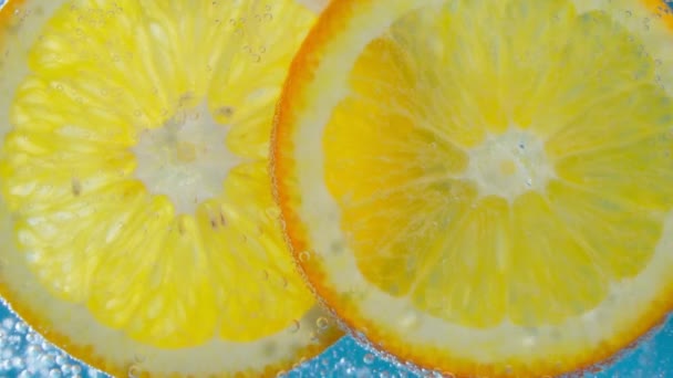 Sinaasappelschijfjes onder water veganistisch en vegetarisch concept. Langzame beweging — Stockvideo