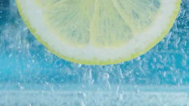 Primer plano de Lemon. Rebanada de limón, burbujas minerales. limonada — Vídeo de stock