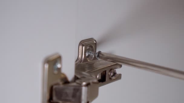Der Schraubenzieher zieht die selbstschneidende Schraube des Türscharniers an. Selektive Fokussierung aus nächster Nähe — Stockvideo