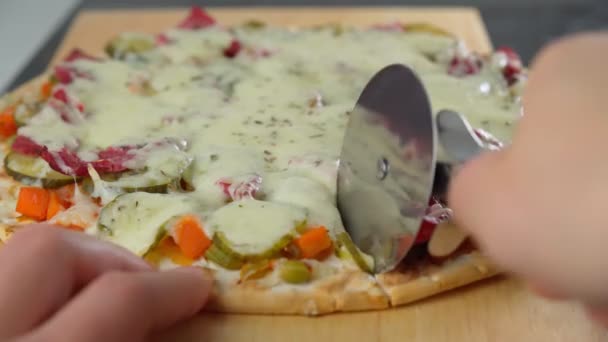 Κόβει μια πίτσα με ένα μαχαίρι πίτσας σε κοντινό πλάνο. Concept για ιταλικό φαγητό, street food, fast food. Επιλεκτική εστίαση — Αρχείο Βίντεο