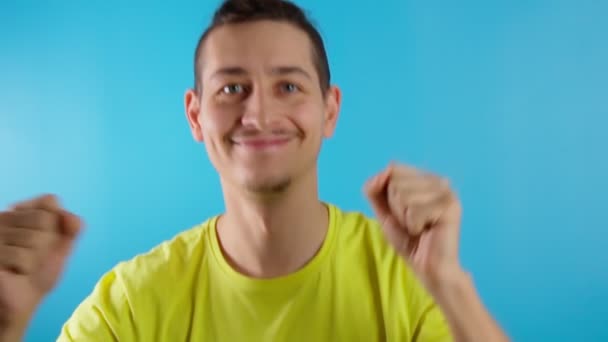 Funky divertido sonriente hombre bailando divertirse sobre fondo de color azul. Movimiento lento — Vídeos de Stock