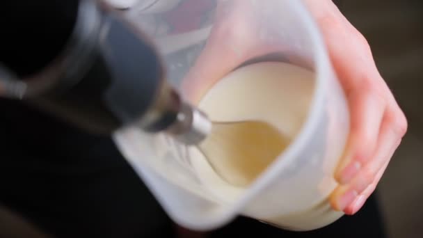 Смешивание белого яичного крема в миске с моторным миксером, выпечка торта. Селективный фокус — стоковое видео