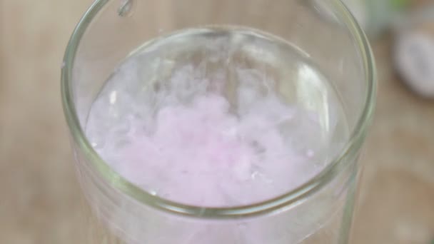 Glass pink paint dissolving in clear water. Selective focus — Stock Video