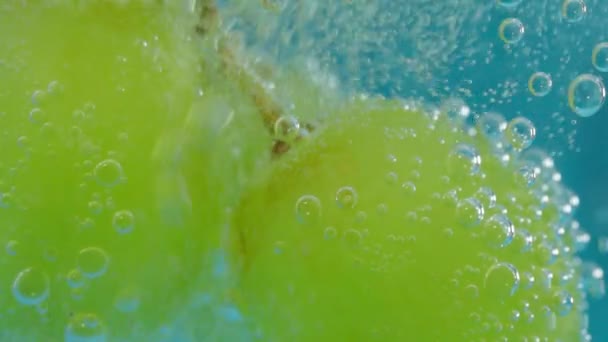 Uvas verdes fruta bajo el agua, enfoque selectivo, macro. Estilo de vida saludable. Un cóctel multivitamínico. Dieta de verano. Movimiento lento — Vídeo de stock