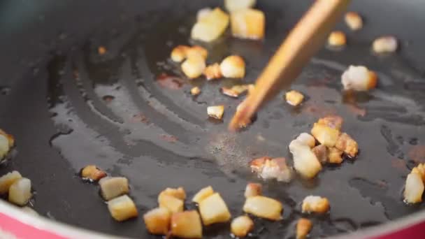 Närbild steka stekande bacon i en kastrull med varm smörjande baconolja för att göra krispig bacon. Fet mat — Stockvideo