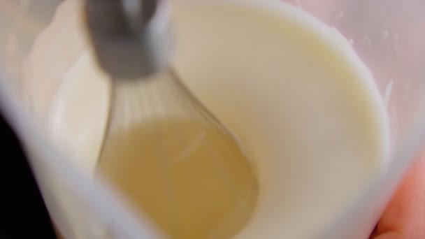 Mixing white egg cream in bowl with motor mixer, baking cake. Selective focus. Slow motion — Stock Video