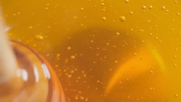 Деревянная медовая ковша с золотым медом и пузырьками воздуха. Крайне близко, макро. Селективный фокус — стоковое видео
