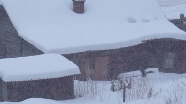 Karla kaplı bir ev. Yoğun bir kar yağışı sonrası eski ahşap ev. Seçici odak — Stok video