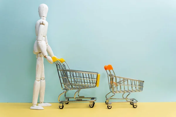 Carrinho Compras Com Manequim Madeira Sacos Compras Fundo Azul Ideia — Fotografia de Stock