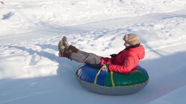Flicka ridning på snöslang, under slangar i vinterparken. Vintersäsong, slow motion — Stockvideo