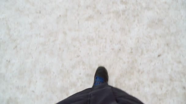 Beine eines Mannes in schwarzen Stiefeln, der im Winter im Schnee spaziert. Pov-Video. — Stockvideo