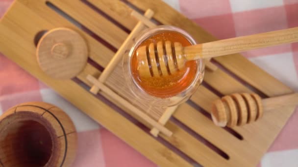 Healthy organic Thick honey dripping from the wooden honey spoon, closeup, macro. Top view — Stock Video