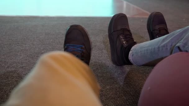 극장 안 바닥에 앉아 있는 한 남자와 소녀의 다리였습니다. 선택적 초점 — 비디오