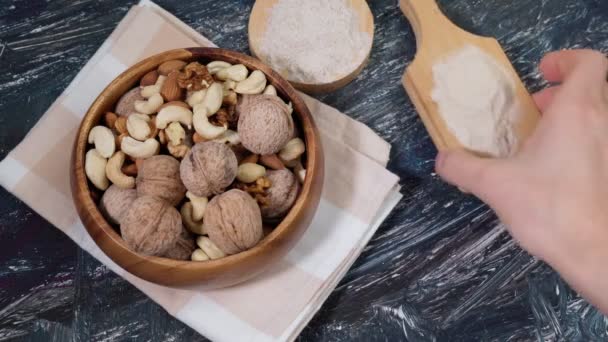 Verschiedenes glutenfreies Mehl Cashewnüsse, Mandeln, Walnüsse. Schwarzer Tisch — Stockvideo