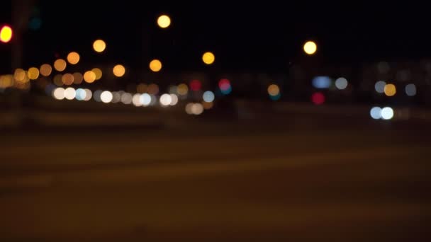 Cerchi sfocati di luci bokeh lampeggianti nella città di notte. Auto di passaggio della città di notte — Video Stock