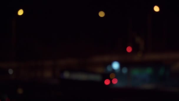 Bokeh sötét homályos háttérrel éjszaka. A kerek színes bokeh ragyog autó fények a város utcájában. Absztrakt fogalom. — Stock videók