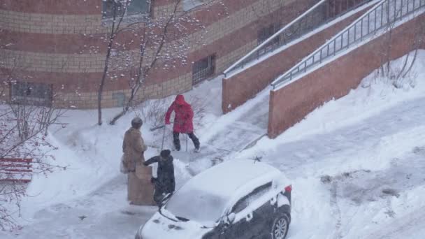 Tyumen, Rusia-Febrero 04, 2022: La gente limpia la nieve cerca de la vista superior de la casa — Vídeos de Stock