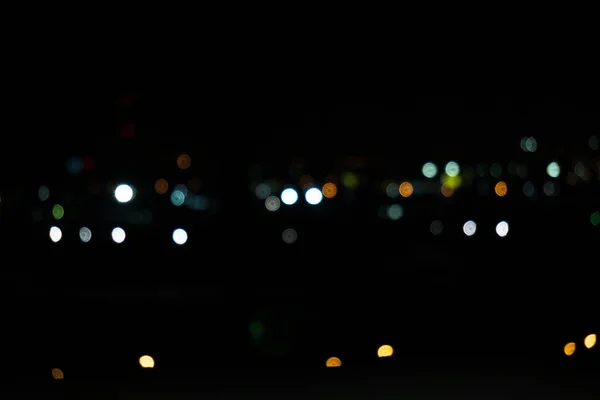 夜の街では ボケの光の円が点滅する 夜市の通過車 — ストック写真