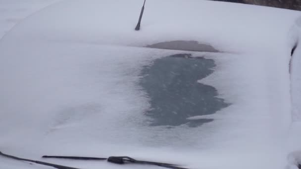 낮에 눈덮인 자동차를 덮고 있는 겨울 주차장은 서서히 움직 이고 있다. 선택적 초점 — 비디오
