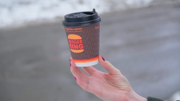 Tyumen, Rusko-23. února 2022: Logo firmy Burger King na šálku kávy na rozmazaném zimním pozadí. Selektivní zaměření — Stock video