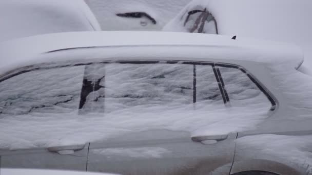 낮에 눈덮인 자동차를 덮고 있는 겨울 주차장은 서서히 움직 이고 있다. 선택적 초점 — 비디오