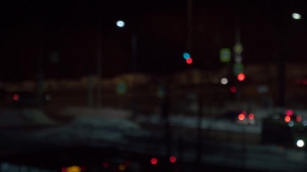 Círculos desenfocados de luces bokeh parpadeando en la ciudad nocturna. Pasando coches de la ciudad nocturna — Vídeo de stock