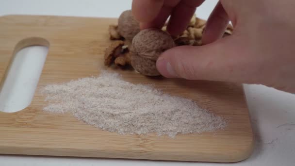 Alternatief walnoten meel. Geraspte walnoten, witte ondergrond. — Stockvideo