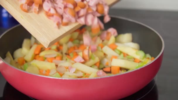 Sausages with vegetables and spices in a pan. Cooking homemade food. Slow motion. — Stock videók