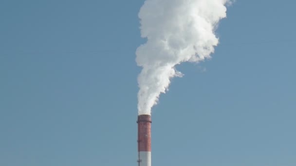 Дым, выбросы из промышленных дымоходов на фоне голубого неба. Копирование пространства — стоковое видео