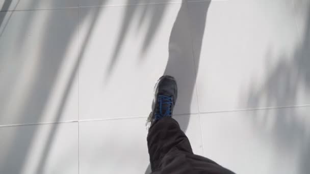 One guy is walking on a tile. First-person point of view on the feet close-up. — Stockvideo