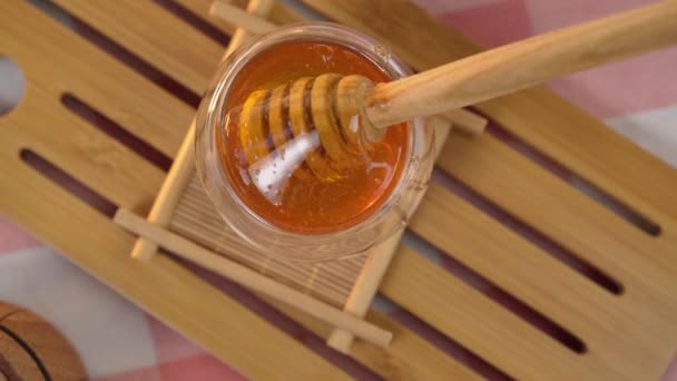 천연 재료의 개념에 근거 한 양봉 제품 인, 떨어지는 꿀 과 함께 나무로 만든 국자 — 비디오