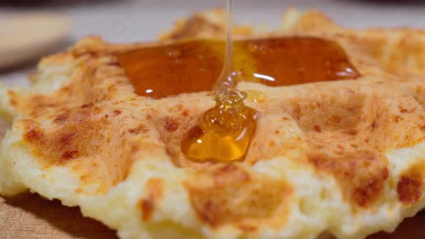 Ρίχνεις μέλι πάνω από ένα σωρό βάφλες. Υγιές πρωινό. — Αρχείο Βίντεο