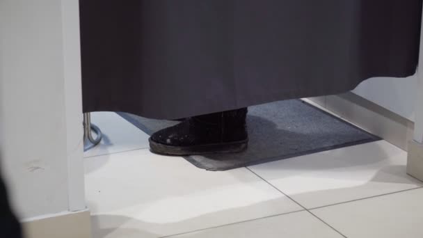 Pieds dans la cabine d'essayage d'un magasin de vêtements. Acheter de nouveaux vêtements — Video