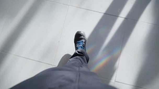 The legs of a man walking a man in boots on a tile. Sunny day — Vídeo de stock