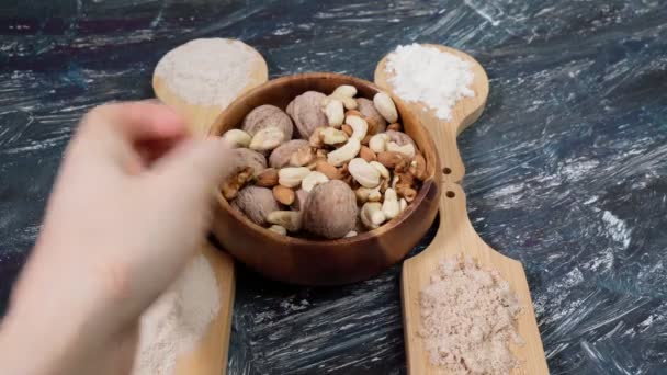 Różne mąki bezglutenowe na czarnym stole z orzechami. Migdały, nerkowce, orzechy włoskie. — Wideo stockowe