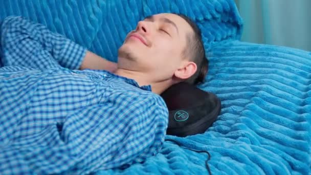 Um homem massagens pescoço com um travesseiro de massagem, corpo se sentir mais relaxado — Vídeo de Stock