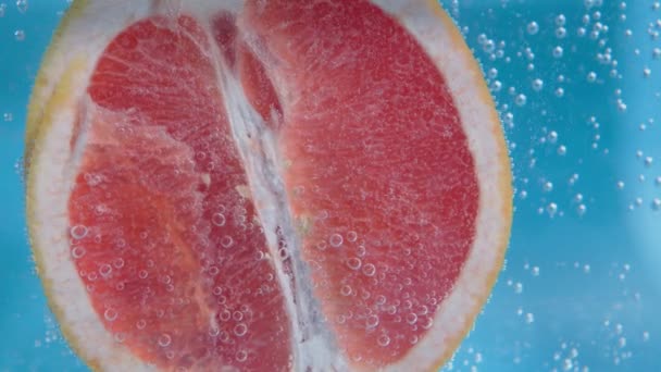 Grapefruit ve vodě pod vodou zblízka. Pozadí, čerstvé ovoce. Selektivní zaměření. — Stock video