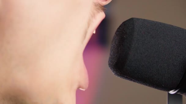 Man singing into a microphone. A spot of light, a musical concept. Selective focus — Stock videók