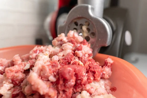 Meat grinder and minced meat falling. Selective focus. Homemade food