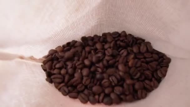 Kaffeebohnen in Großaufnahme in einer Tüte, Weitwinkel. Selektiver Fokus. Zeitlupe — Stockvideo