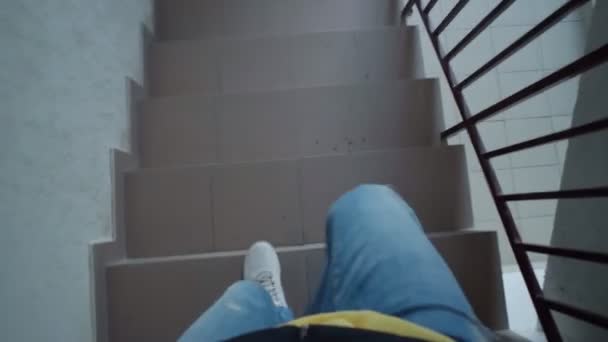 The legs of a man in white sneakers going down the stairs. Selective focus — Stock Video