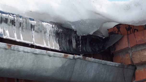 Roof gutter cleaning in spring. Water when snow is melting. Selective focus slow motion — Vídeo de stock