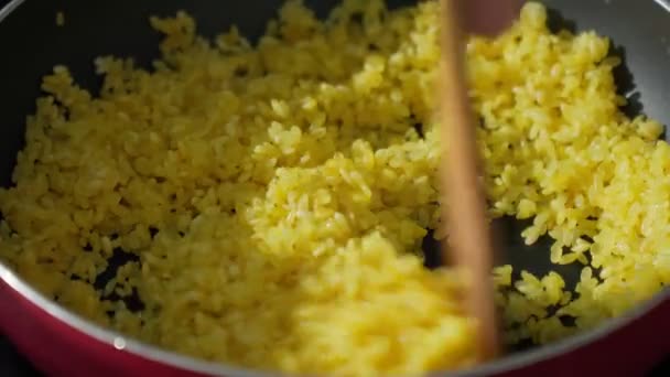 Cooking rice with curry seasoning, close-up selective focus — Stock Video